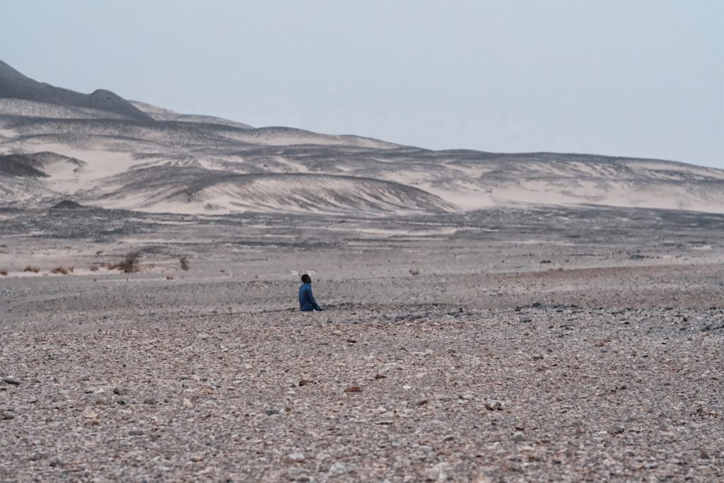 Un autista prega vicino alle miniere d'oro di Aouzouger, lungo la rotta sahariana verso la Libia (foto: Giacomo Zandonini) 