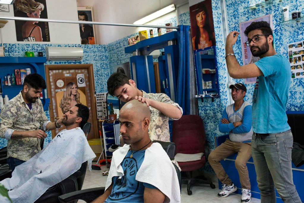 Pontinia (Lt) - 2016. Keshav taglia i capelli di Charanjeet. Nella comunità Sikh i barbieri hanno un ruolo particolare in quanto, secondo la loro religione, un credente non dovrebbe mai tagliarsi i capelli. Ad ogni modo è concesso e tollerato essere credenti “alla moda” (foto: Marco Valle)