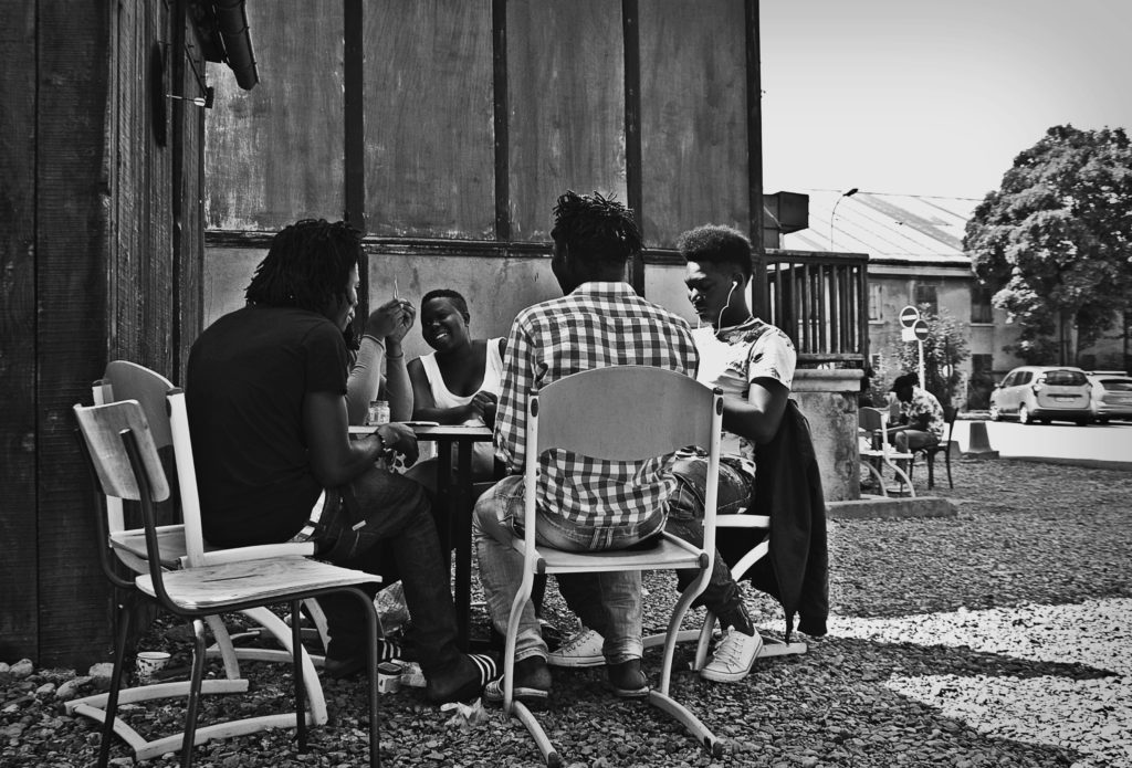 Alcuni migranti ospiti del centro di accoglienza Tous Migrants di Briançon ingannano l'attesa con un gioco di carte. Tra loro anche donne incinte e minori. 13 agosto 2018 (foto: Marta Clinco)